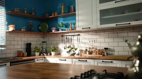 Ahşap tezgâhlı mutfak adası ve arka plandaki raflar